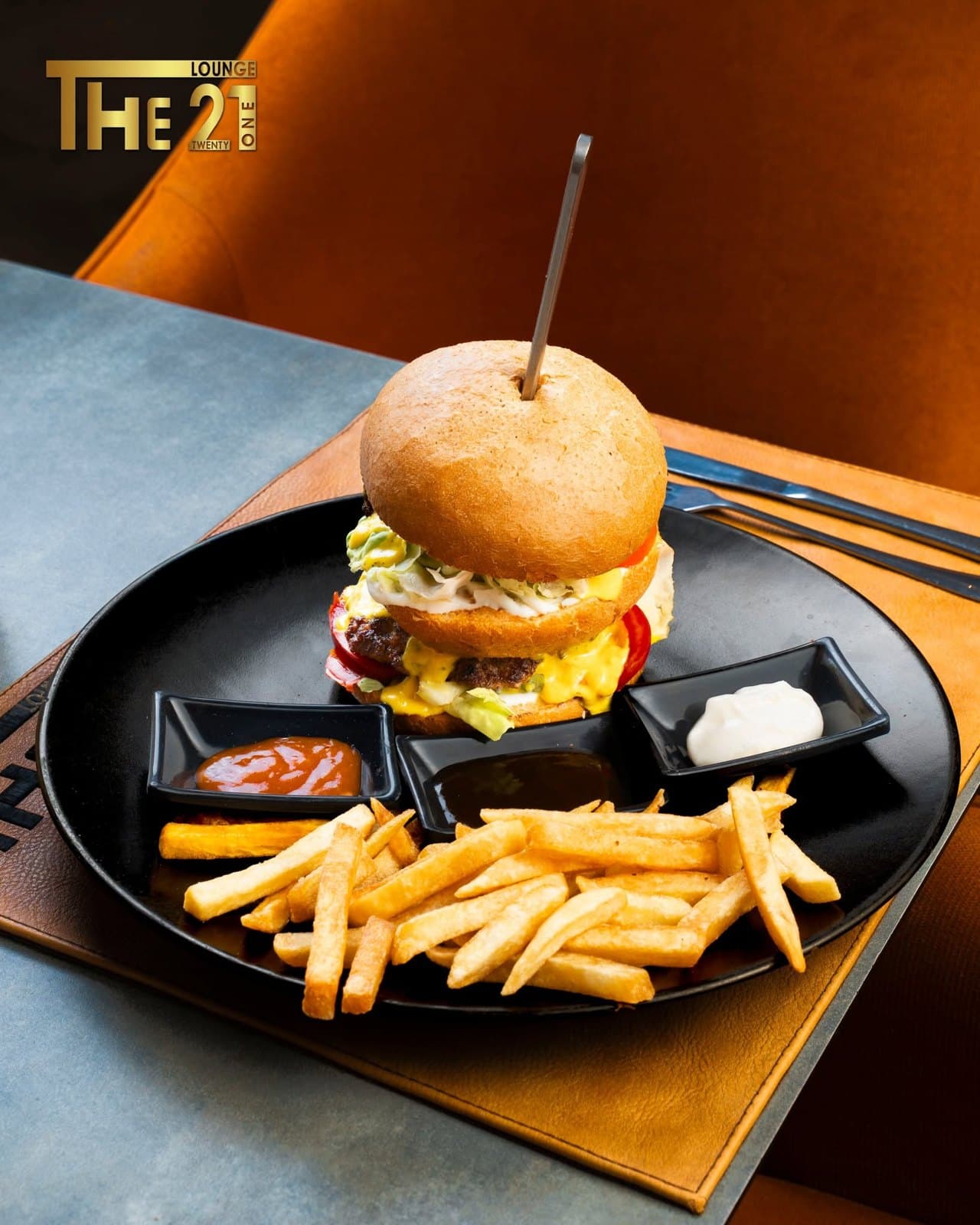 Burger The 21 servi avec des frites et des sauces