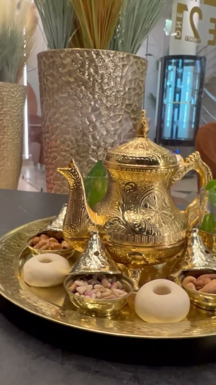 Service à thé doré avec menthe fraîche et coupelles de fruits secs